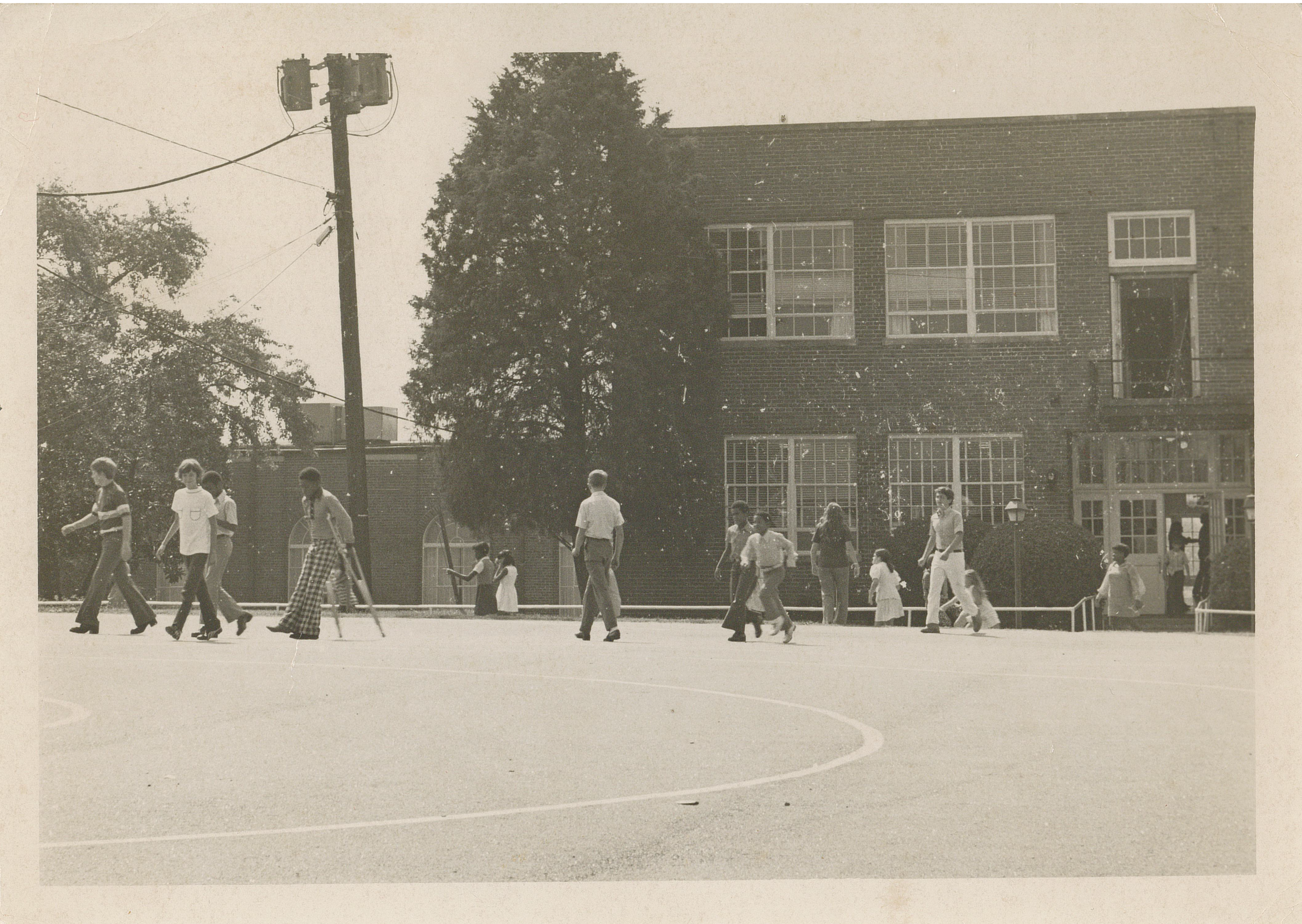 An antique sepia photo depicts students walking around outside Parnell Hall during the 1970s.